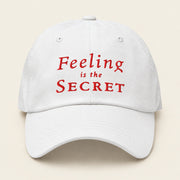 FEELING IS THE SECRET with Neville Goddard Dad Cap in White, front